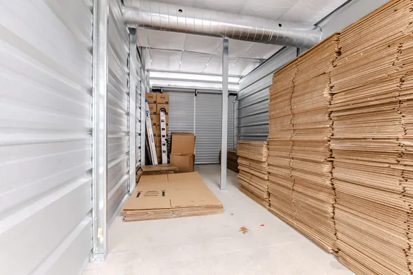 Inside a 10x20 indoor storage unit, stacked with flat moving boxes